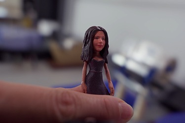A small Minikin figurine balanced on a fingertip